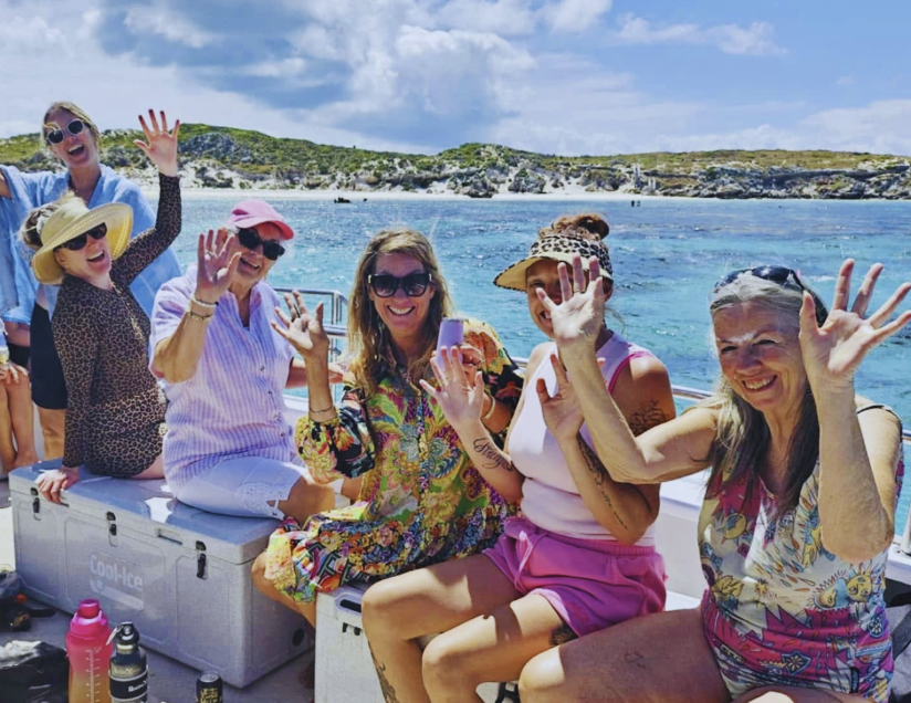 Ladies waving and laughing on a boat at the Abrolhos Islands