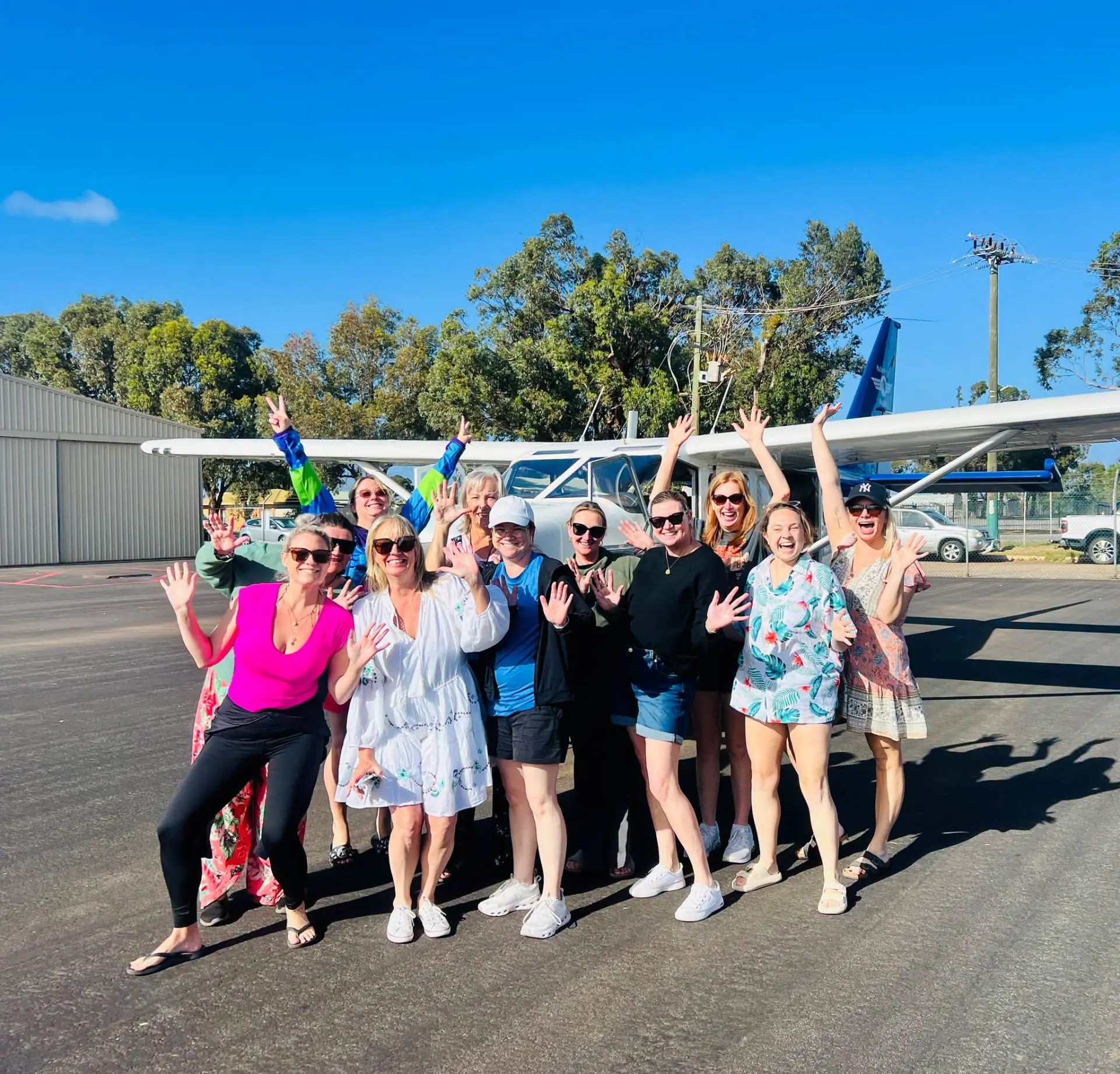 The Ladies HQ group celebrating in front of the scenic flight plane
